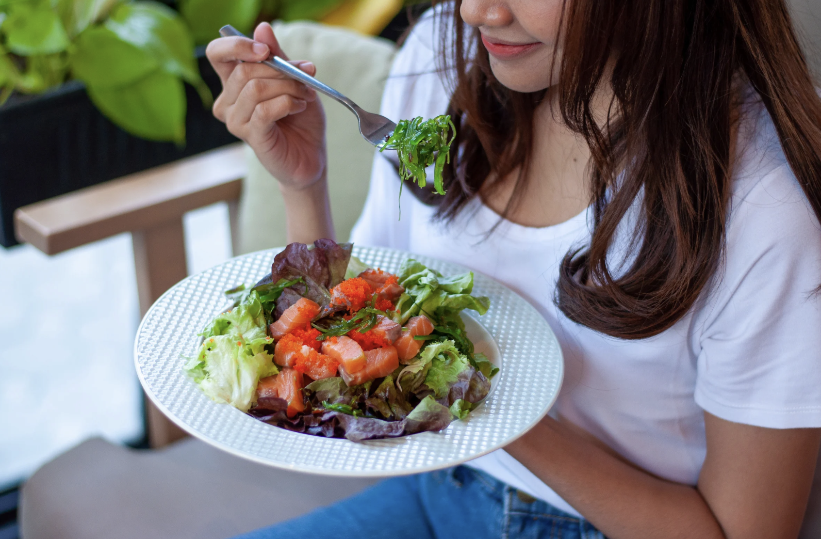 Woman holding a bowl of salad.